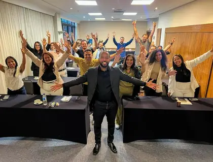 Turma de mentores comemorando com as mãos para cima ao lado de Mateus Menezes